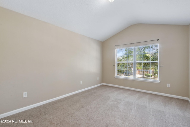 empty room featuring carpet floors and lofted ceiling