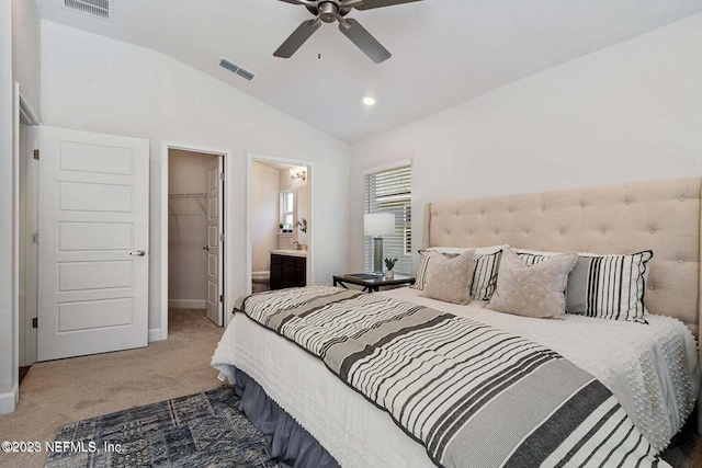 carpeted bedroom with a walk in closet, ensuite bath, ceiling fan, a closet, and lofted ceiling