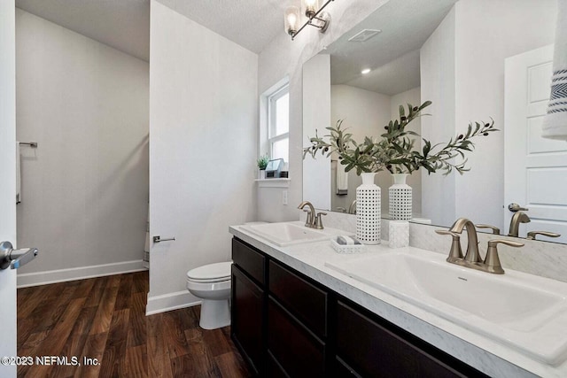 bathroom featuring toilet, vanity, a textured ceiling, and hardwood / wood-style flooring