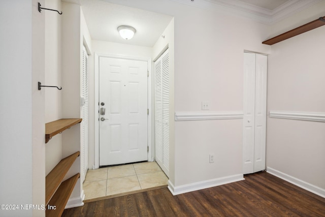 entryway with dark hardwood / wood-style flooring and crown molding