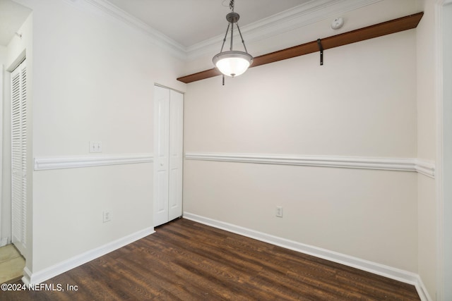 unfurnished dining area featuring dark hardwood / wood-style floors and crown molding