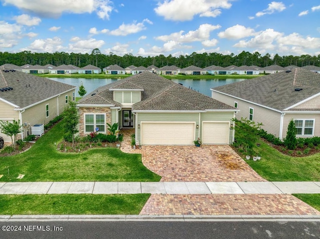 view of front of home featuring a water view, a front lawn, and a garage