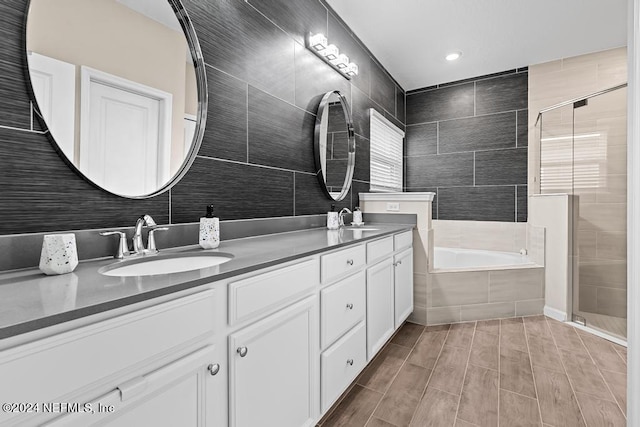 bathroom featuring vanity, separate shower and tub, and tile walls