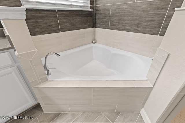 bathroom featuring tiled tub