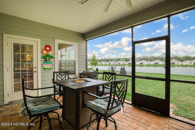 sunroom featuring a water view