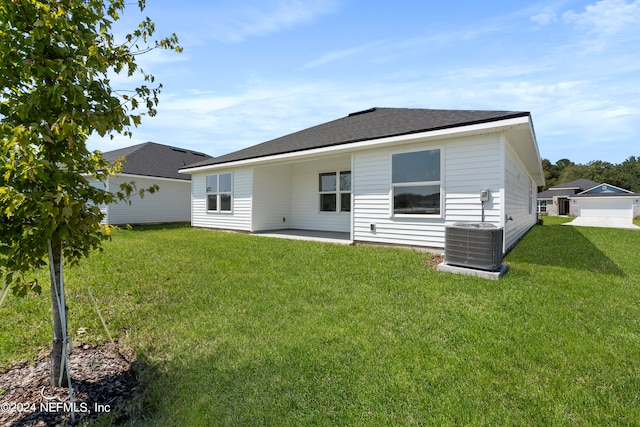 rear view of property featuring central air condition unit, a patio area, and a lawn