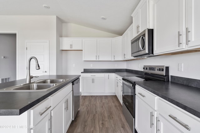 kitchen with white cabinetry, sink, vaulted ceiling, and appliances with stainless steel finishes