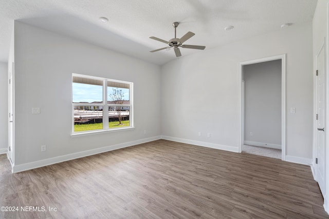 spare room with wood-type flooring, vaulted ceiling, and ceiling fan