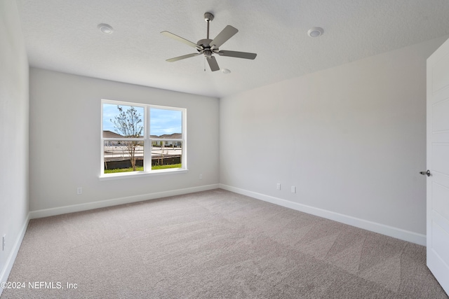 spare room featuring ceiling fan, carpet floors, and a textured ceiling