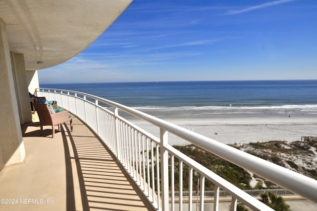 balcony featuring a water view and a view of the beach