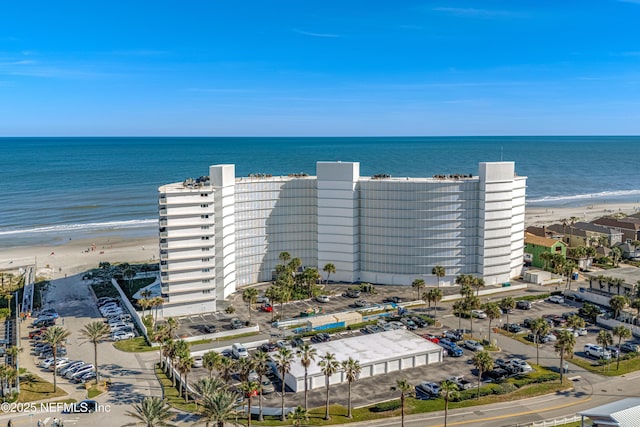 birds eye view of property with a water view and a beach view