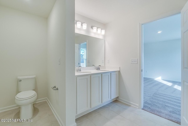 bathroom with tile patterned flooring, double vanity, toilet, and a sink