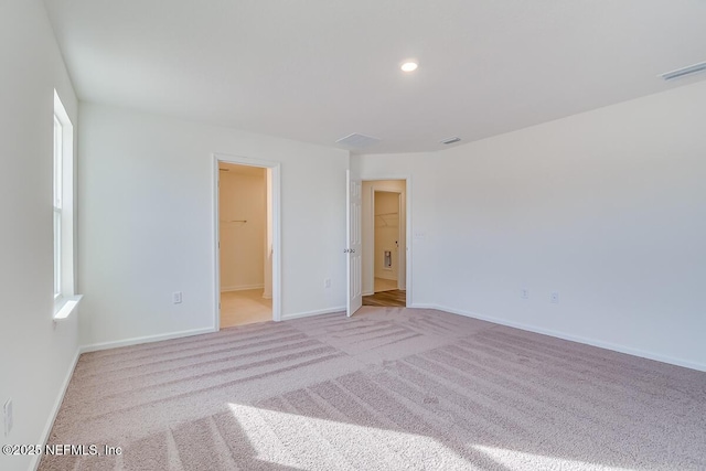 unfurnished bedroom featuring visible vents, recessed lighting, carpet flooring, baseboards, and a spacious closet