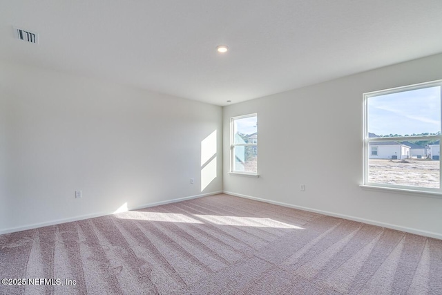 carpeted spare room with recessed lighting, visible vents, and baseboards