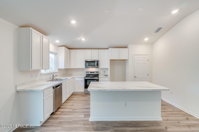 kitchen featuring light stone counters, visible vents, white cabinetry, and stainless steel appliances