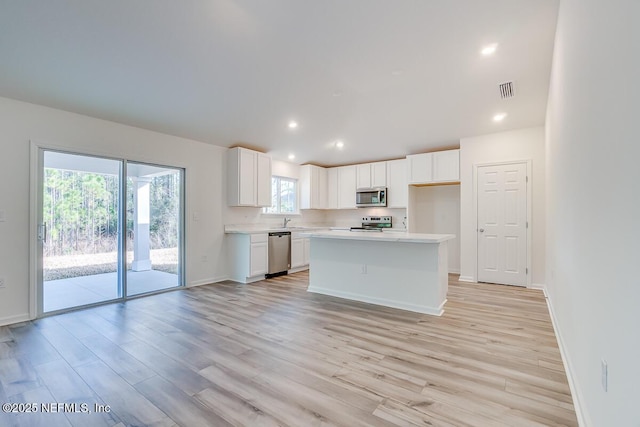 kitchen featuring white cabinetry, light countertops, light wood-style floors, and stainless steel appliances