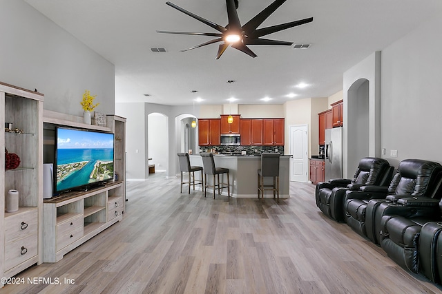 living room with ceiling fan and light wood-type flooring