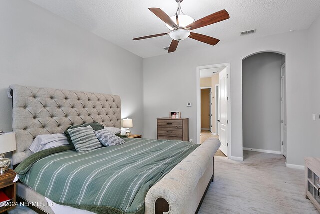 carpeted bedroom with ceiling fan and a textured ceiling