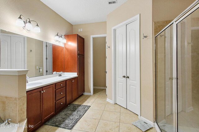 bathroom with tile patterned flooring, vanity, and a shower with shower door