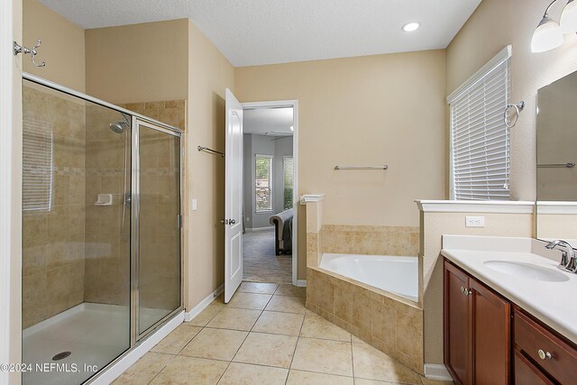 bathroom with tile patterned floors, separate shower and tub, and vanity