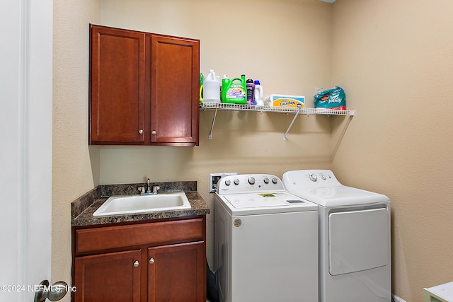 laundry room featuring cabinets, separate washer and dryer, and sink