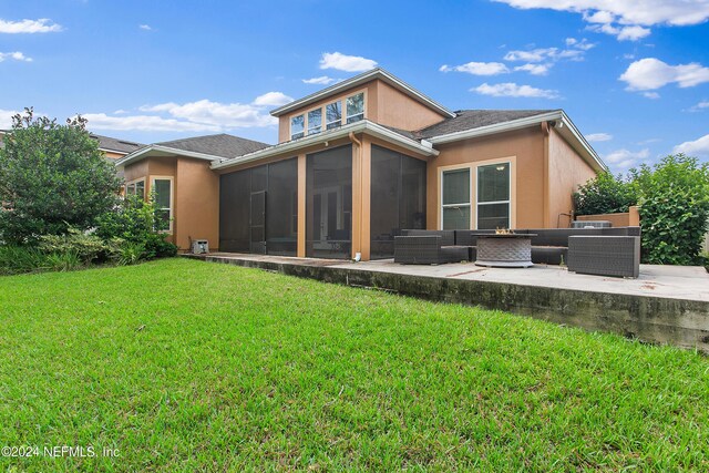 back of house with a sunroom, an outdoor living space, a patio area, and a lawn