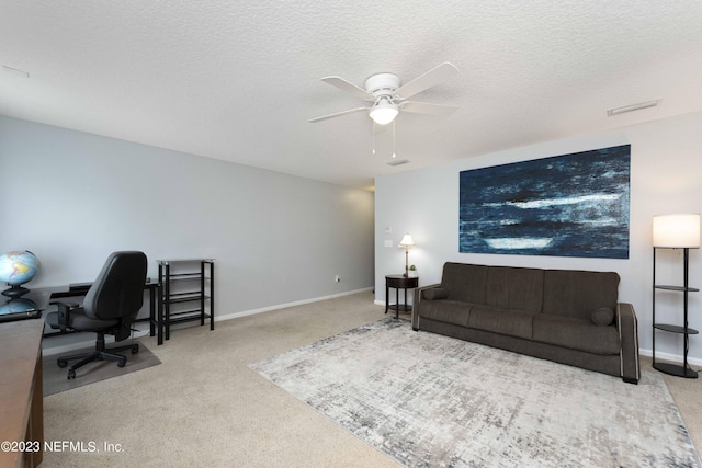 office area featuring a textured ceiling, ceiling fan, and light colored carpet