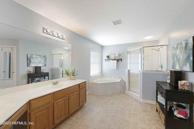 bathroom with a textured ceiling, plus walk in shower, and vanity