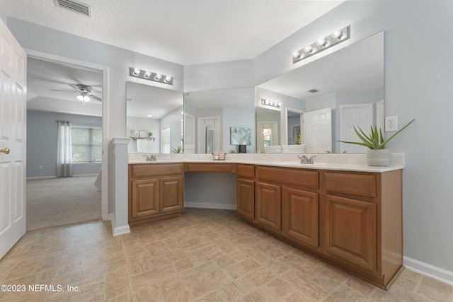 bathroom with vanity, a textured ceiling, and ceiling fan