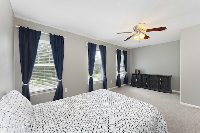 carpeted bedroom with multiple windows and ceiling fan