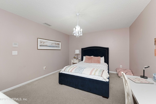 carpeted bedroom featuring an inviting chandelier and a textured ceiling