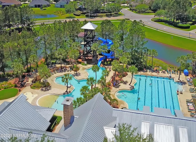 view of pool featuring a water slide, a patio area, and a water view