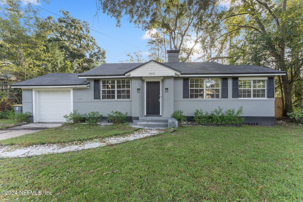 single story home featuring a garage and a front yard