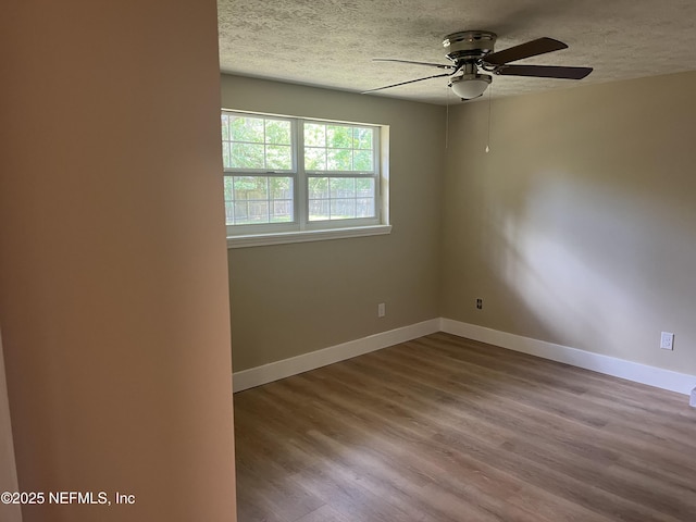 empty room with a textured ceiling, light hardwood / wood-style floors, and ceiling fan