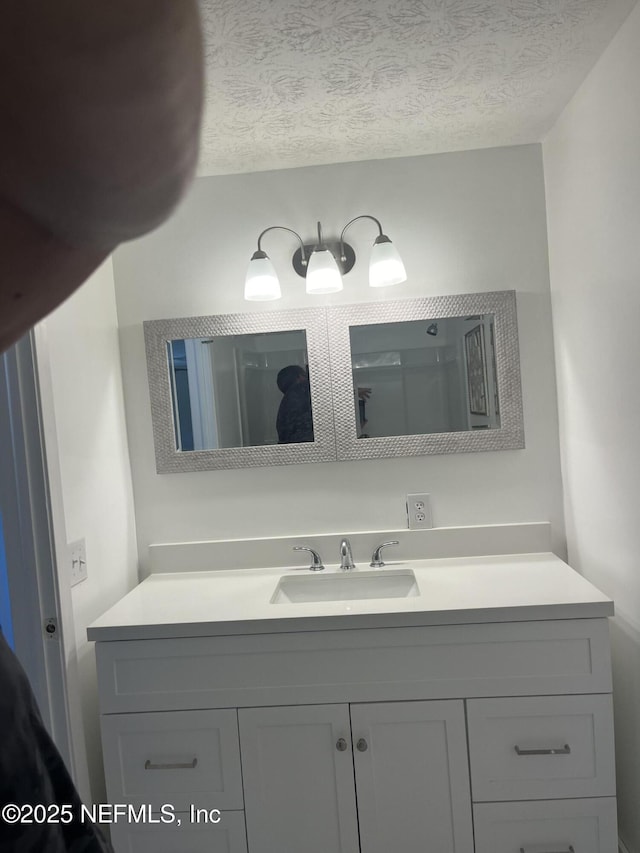 bathroom with vanity and a textured ceiling