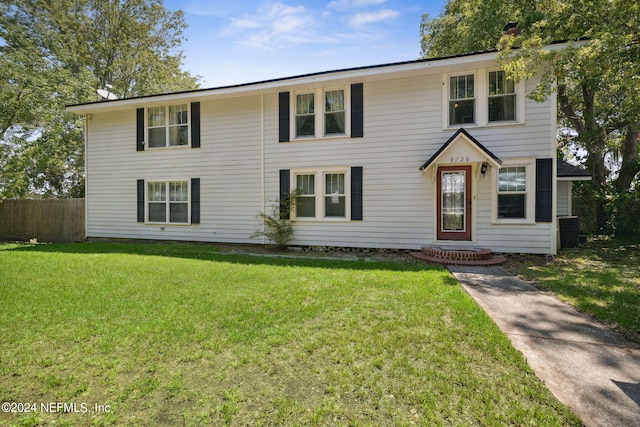 view of front of home with cooling unit and a front yard