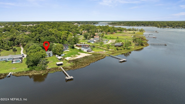 birds eye view of property with a water view and a wooded view