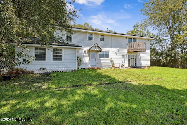 rear view of property featuring a yard, a balcony, and fence