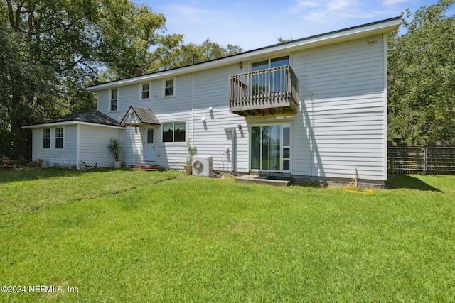 rear view of property featuring a lawn, a balcony, and ac unit