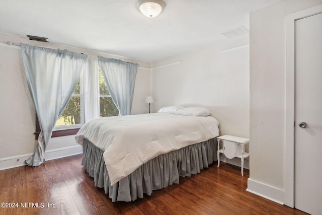 bedroom featuring dark wood-type flooring, visible vents, and baseboards