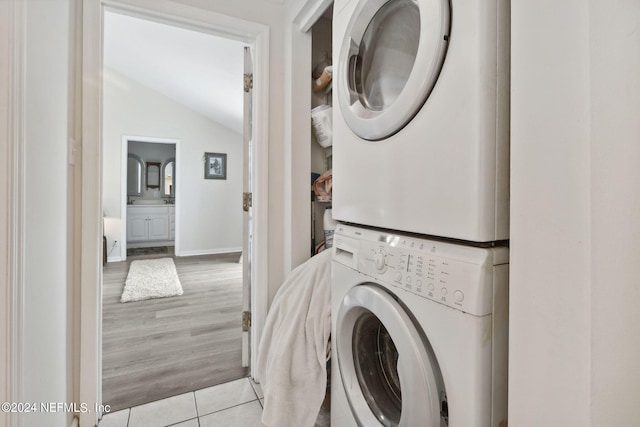 laundry area featuring stacked washer and dryer and light tile patterned floors