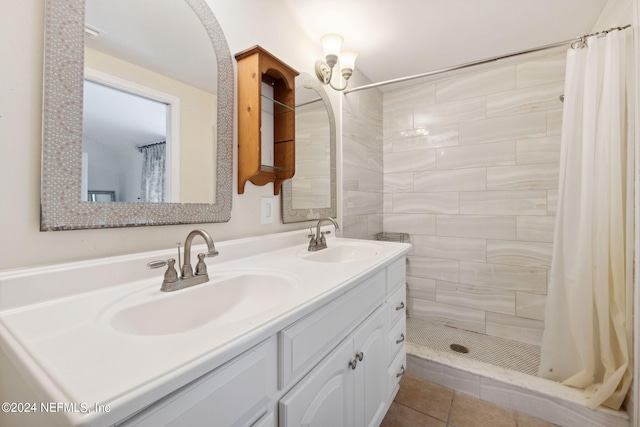 full bath featuring tile patterned flooring, a sink, a tile shower, and double vanity