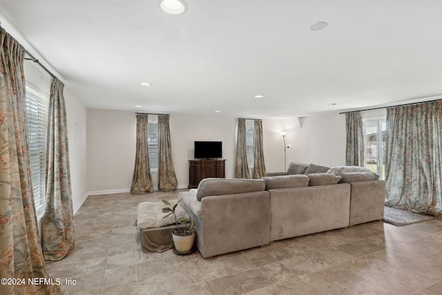 living area with baseboards, plenty of natural light, and recessed lighting