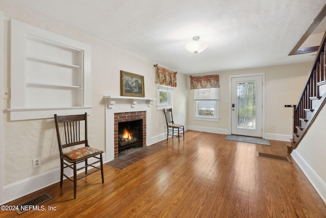 foyer with visible vents, baseboards, hardwood / wood-style floors, stairs, and a fireplace