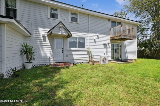 back of property featuring a lawn, ac unit, and a balcony