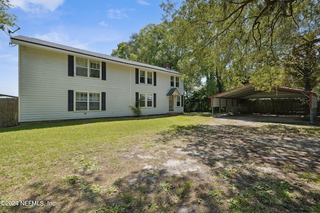 rear view of house with a carport and a lawn