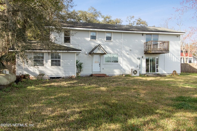 back of property featuring entry steps, a balcony, fence, a lawn, and ac unit