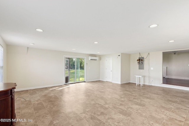 spare room featuring baseboards, an AC wall unit, and recessed lighting