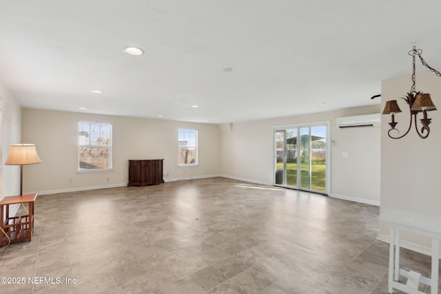 unfurnished living room featuring recessed lighting, a wall unit AC, and baseboards