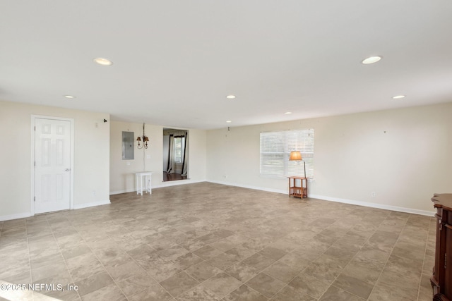 unfurnished living room featuring baseboards, electric panel, and recessed lighting